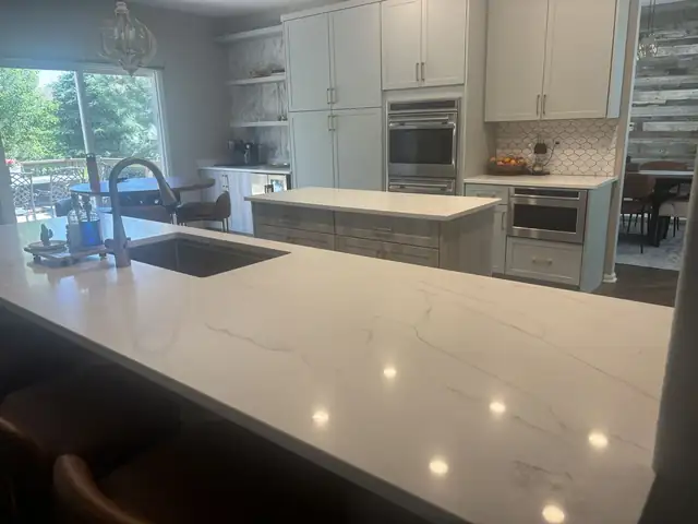 White quartz countertop with gray veining and undermount sink in a kitchen with white cabinets