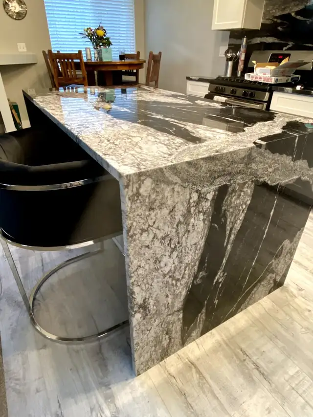 Black and white granite bar top with waterfall edge and bar stools