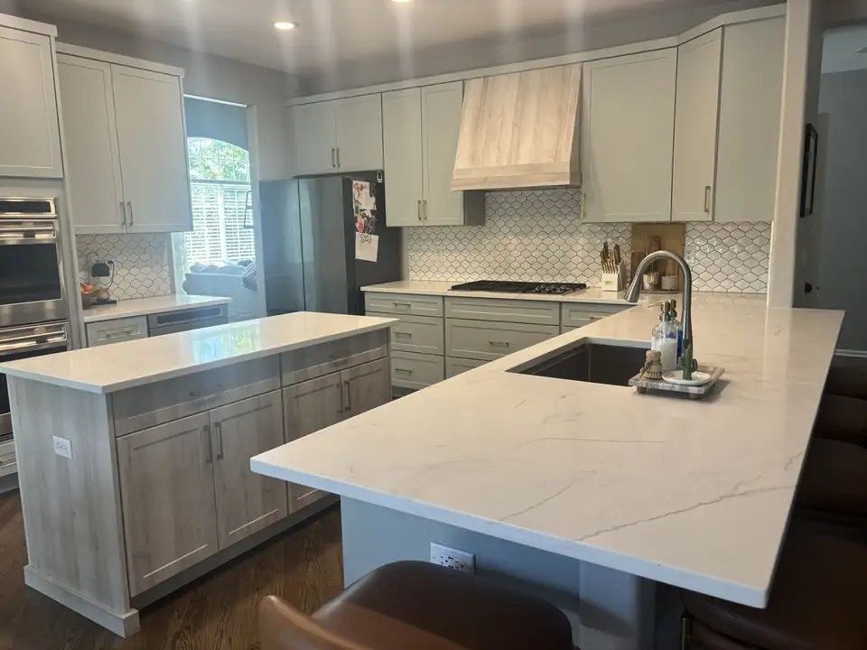 White quartz island and peninsula over gray shaker cabinets, installed by VL Granite & Marble, who also fit granite countertops in Sheridan, CO